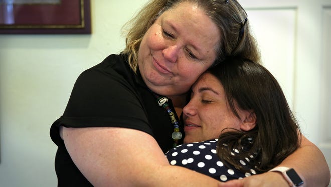 Oasis Center for Women & Girls founder Kelly Otte (left) hugs outgoing Executive Director and mentee Haley Cutler-Seeber goodbye at Cutler-Seeber's "Bon Voyage" party held Thursday at the Oasis Center.