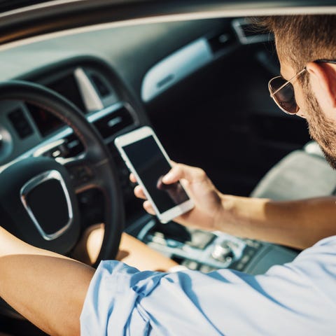 Photograph of Ube driver in car holding a smartpho