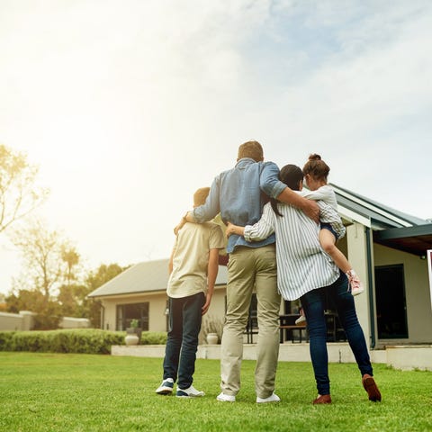 A family stands in the front yard of a home for sa