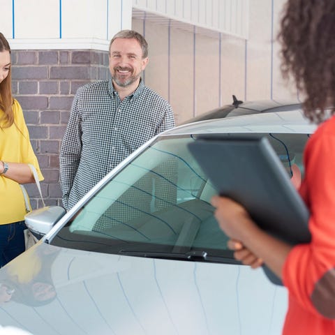 A father and daughter shopping for a used car toge