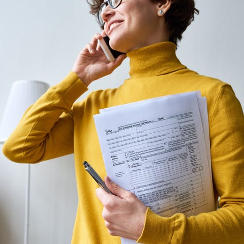 A person holding tax forms.