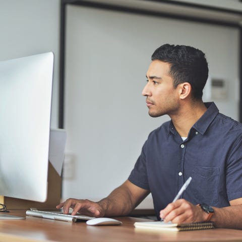 A person at a computer taking notes.