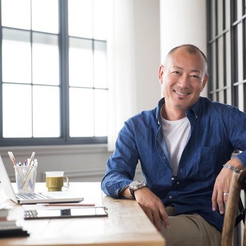 A smiling person at a desk.