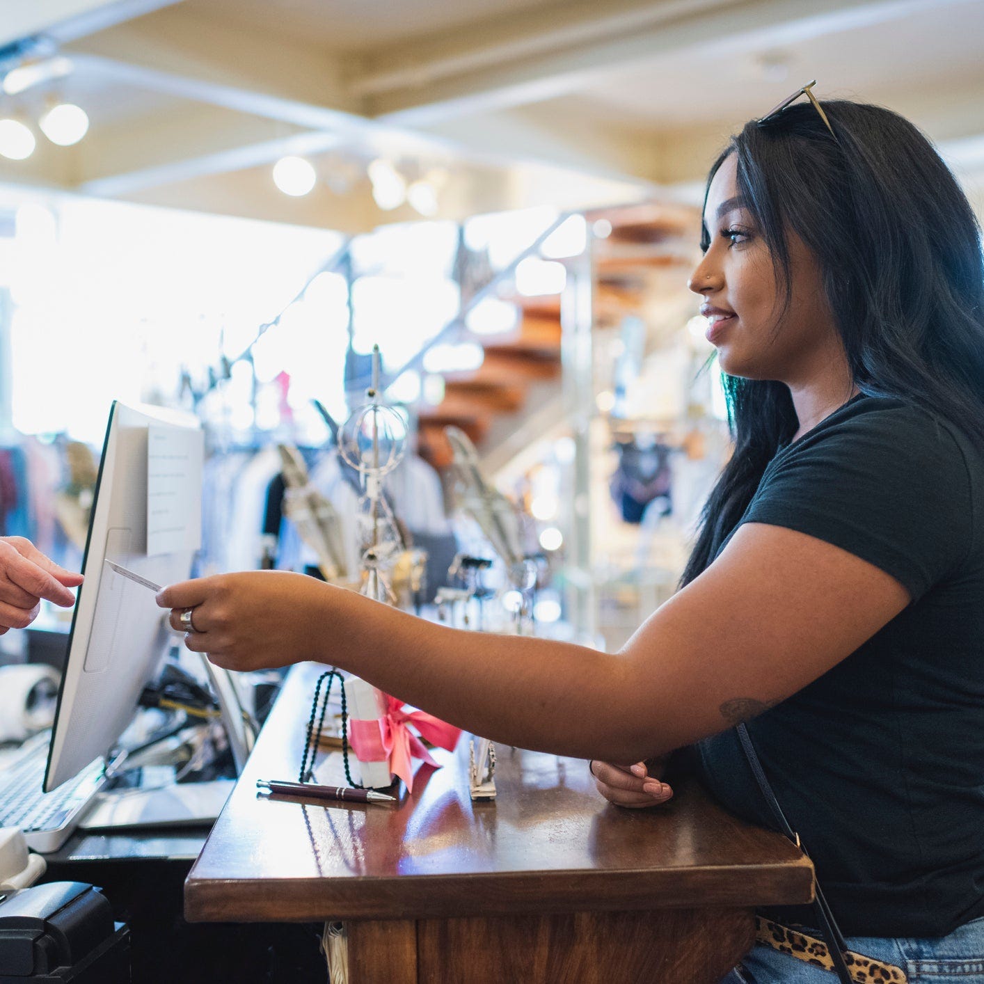 A customer handing over a credit card in a boutique.