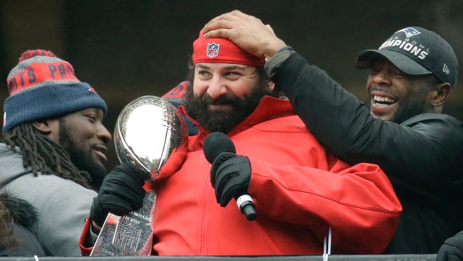Malcolm Butler, right, jokes with Matt Patricia, as he holds the Vince Lombardi trophy and addresses the crowd during a rally Feb. 7, 2017 in Boston to celebrate New England's 34-28 win over the Falcons in the Super Bowl.