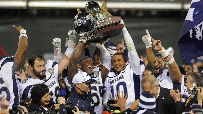 Wolf Pack players Dontay Moch (55) and Colin Kaepernick hoist the Kraft Fight Hunger Bowl trophy to cap off their remarkable 2010 season in which the team finished 11th in the nation.