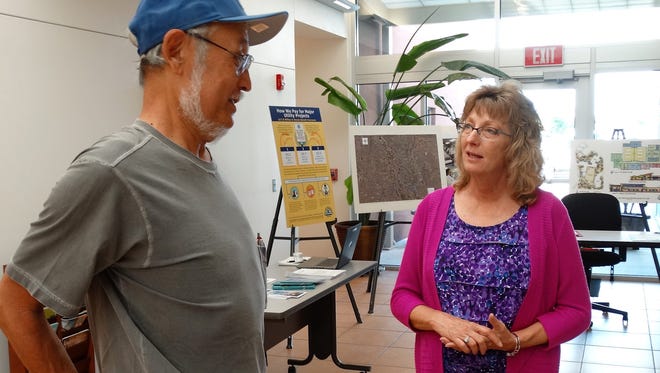 Adrienne L. Widmer, water section administrator, speaks to a Las Cruces Utilities customer during an open house.