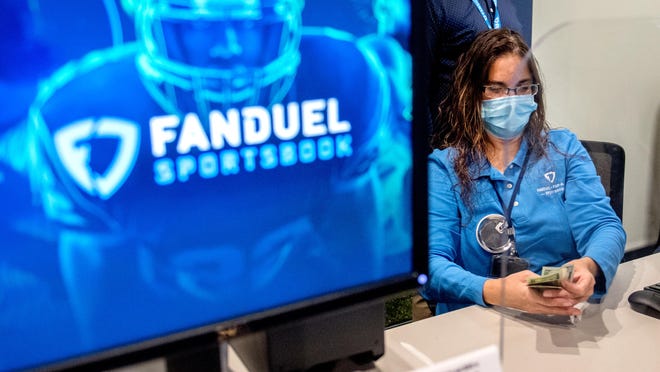 Cashier Tammy McGinnis counts the cash from a recent bettor at the new FanDuel betting facility that opened Thursday, Sept. 10, 2020 at the Par-A-Dice Casino in East Peoria. The in-person sportsbook opened in conjunction with the release of an app for FanDuel's online sports betting service in partnership with Boyd Gaming, the owners of the Par-A-Dice.