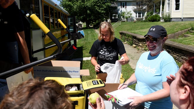 Ben Franklin Elementary second grade teacher Krysta Campbell packs a lunch bag as school literacy coordinator Jen Stokes keeps notes how many lunches they've handed out at their Everett Avenue stop. Several Newark City Schools buses visited various spots across the district to provide free lunches to school-aged children on Friday, Jun 15, 2018. The program will continue through June 29. Staff members are also available to answer questions about registering for school.
