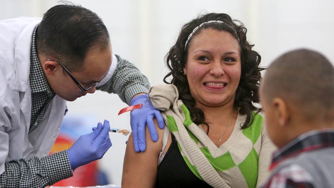 Walgreens pharmacist Chris Nguyen gives a free flu shot to Sandra Bazaldua in Houston, Texas.