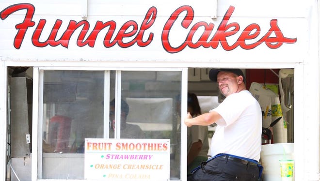 Mark Abrams sits in the window of Nancy's Fried Dough at Corn Hill Festival on July 11, 2015.