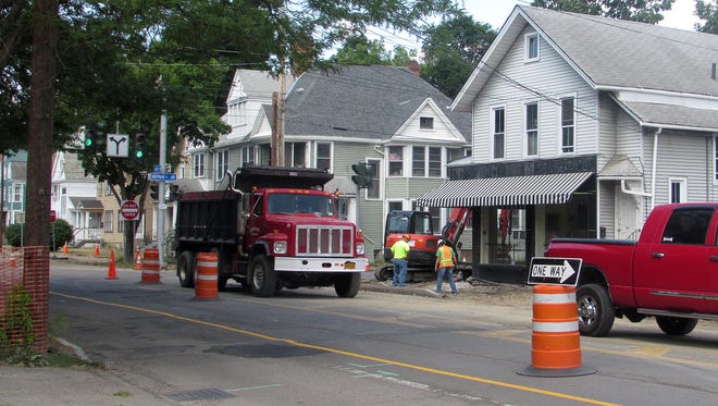 A crew tears up the sidewalk Tuesday at the intersection of West Water and Hoffman streets in Elmira.