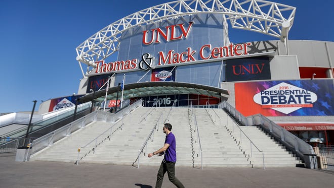 A pedestrian walks past the site for the third presidential debate between Republican presidential nominee Donald Trump and Democratic presidential nominee Hillary Clinton at UNLV in Las Vegas, Tuesday, Oct. 18, 2016.