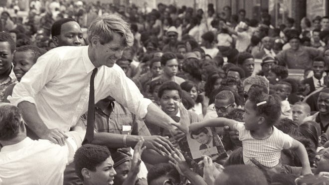 Sen. Robert Kennedy clasps the hand of an unidentified girl near the intersection of 12th Street and Clairmount on his May 15, 1968 visit to Detroit, the last time he visited Michigan before his assassination that June.