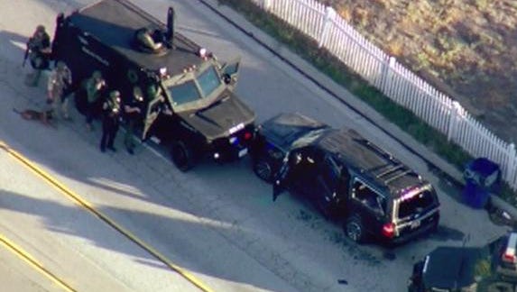 In this image taken from video, armored vehicles surround an SUV following a shootout in San Bernardino, Calif., Wednesday, Dec. 2, 2015. The scene followed a military-style attack that killed multiple people and wounded others at a California center that serves people with developmental disabilities, authorities said.   (KTTV via AP)