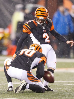 The Bengals' Mike Nugent kicks, with Kevin Huber holding.