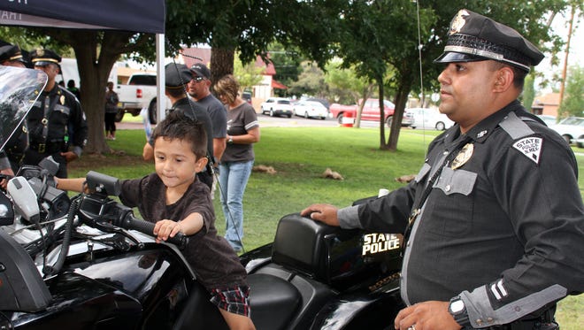 The thrill of sitting in the cockpit of a New Mexico State Police motorcycle is etched on this child's face.