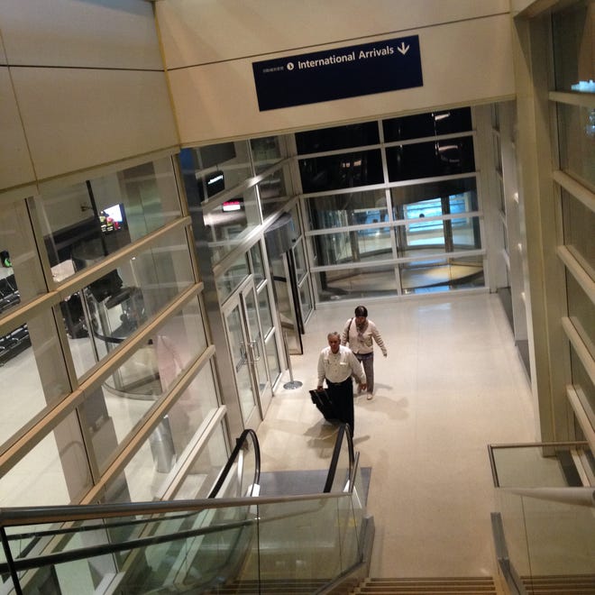 Passengers exit international arrivals area at Detroit Metro Airport McNamara Terminal today in Romulus, Mich.