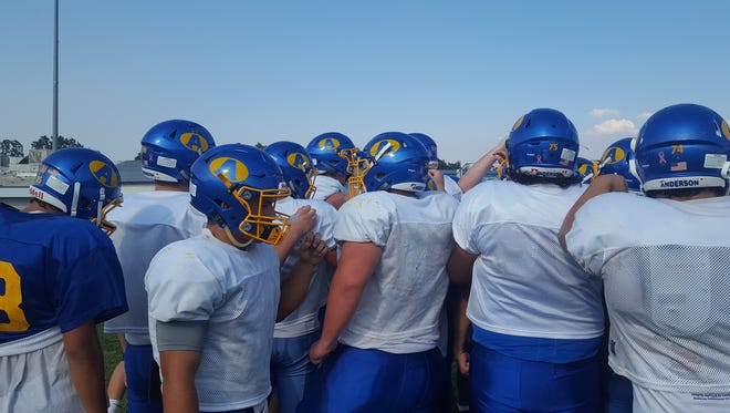 Anderson High football players go into a huddle during an August 2017 practice.