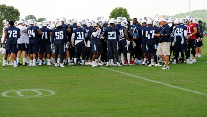 Titans players huddle before the start of practice June 14.