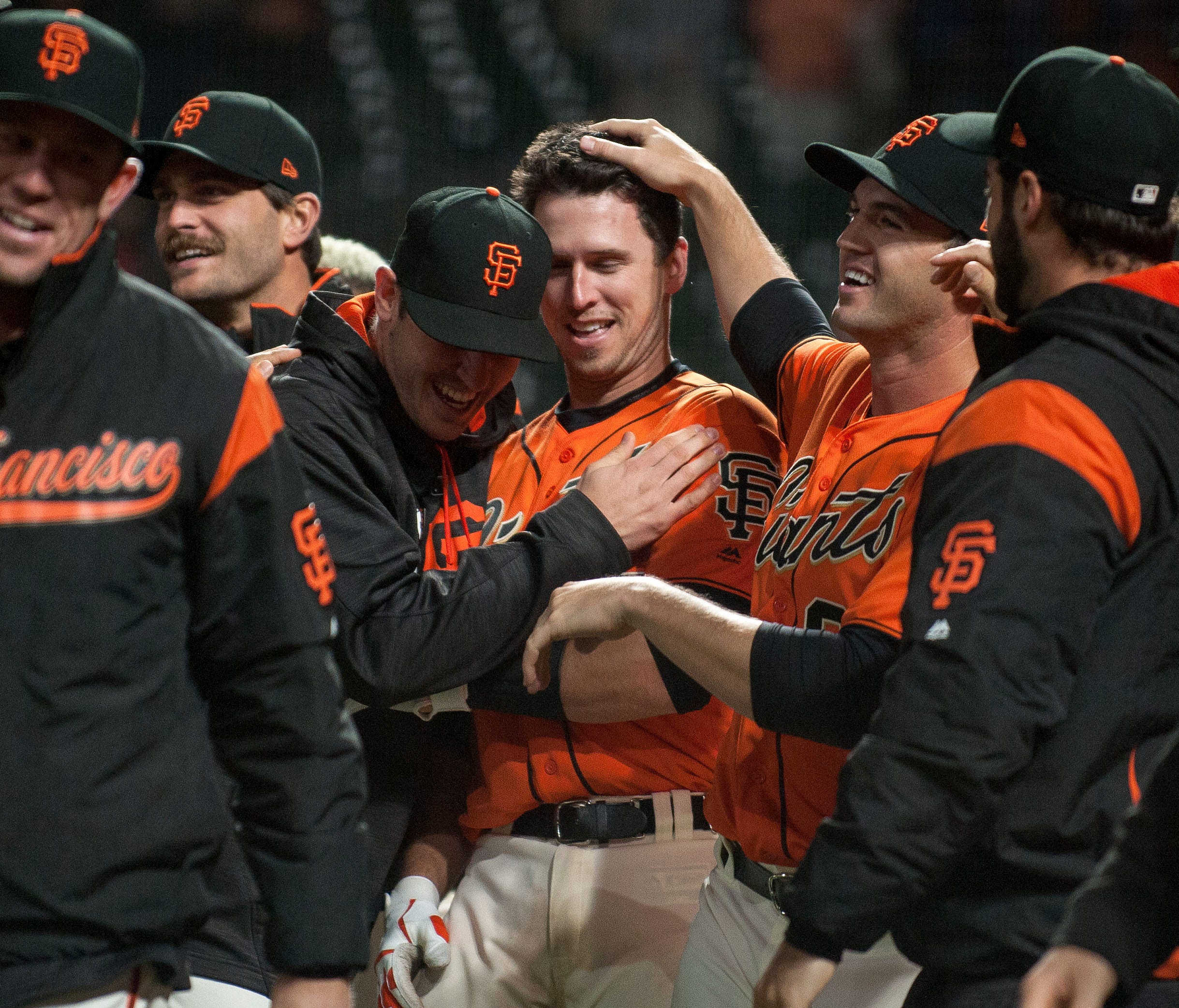 San Francisco Giants catcher Buster Posey (28) celebrates with teammates at home plate after hitting a walk-off home run during the 17th inning against the Cincinnati Reds.