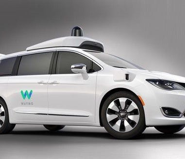 A Chrysler Pacifica hubrid minivan, decked out in Waymo's colors and self-driving technology.