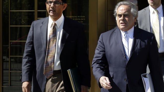 FILE - In this May 20, 2014 file photo, conservative scholar and filmmaker Dinesh D'Souza, left, accompanied by his lawyer Benjamin Brafman leaves federal court, in New York. President Donald Trump says he will pardon conservative commentator Dinesh D'Souza who pleaded guilty to campaign finance fraud. Trump tweeted Thursday: âWill be giving a Full Pardon to Dinesh DâSouza today. He was treated very unfairly by our government!â DâSouza was sentenced in 2014 to five yearsâ probation after he pleaded guilty to violating federal election law. (AP Photo/Richard Drew)