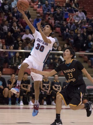 Shiprock's Arvin Begay drives past Navajo Prep's Trejan Clichee in the first quarter on Thursday at the Chieftain Pit in Shiprock.