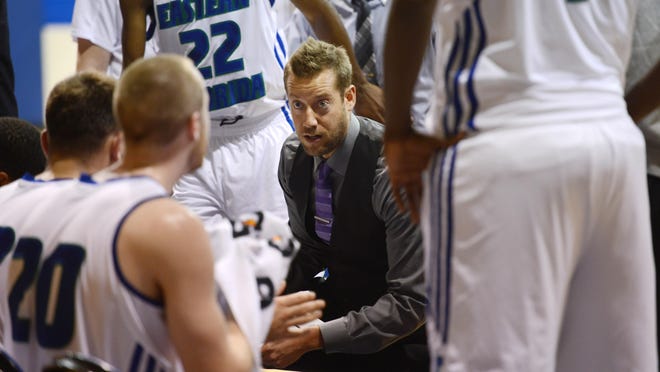 Eastern Florida basketball coach Jeremy Shulman talks with his players during a timeout.