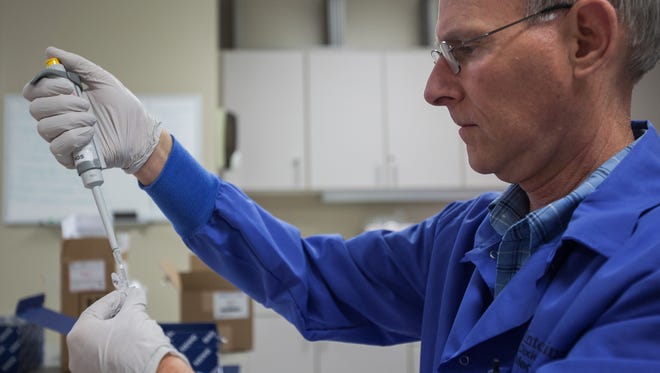 Medical Technologist Pat Bradley measures out a portion of DNA to be sent to a lab in this file photo.