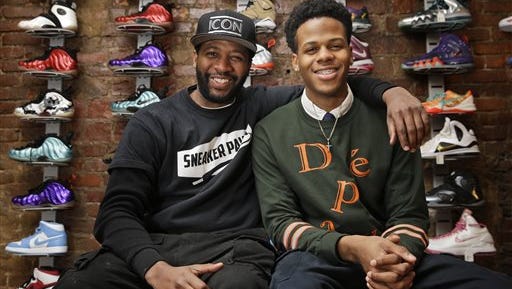 Entrepreneurs Chase Reed, right, and his father Troy Reed pose for a picture in their store in the Harlem section of New York. The Reeds run Sneaker Pawn, a store that capitalizes on America’s multi-billion dollar athletic footwear market and the high prices sneakers can get being re-sold.