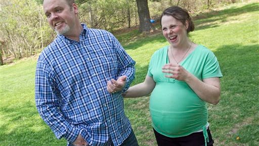 Kateri and Jay Schwandt stand outside their Rockford, Mich. home Wednesday, May 6, 2015. The couple, have 12 boys, and are expecting a baby on May 9, the day before Mother's Day, and they're sticking to their tradition of not finding out in advance whether they're having a boy or girl.