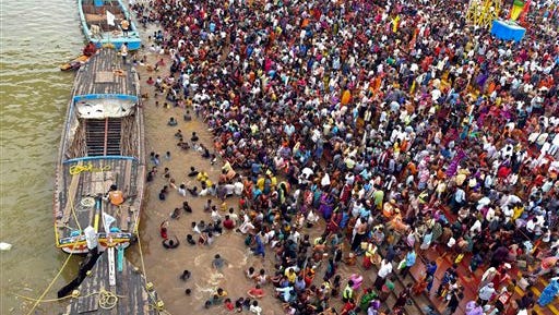 Thousands of people gather during a Hindu religious bathing festival on the bank of the Godavari River in Rajahmundry, Andhra Pradesh state, India, Tuesday, July 14, 2015. At least two dozen people were killed and dozens injured Tuesday in a stampede as tens of thousands of people pushed forward to bathe in the river on the first day of the Pushkaralu festival, an official said. (AP Photo/ Ramana)