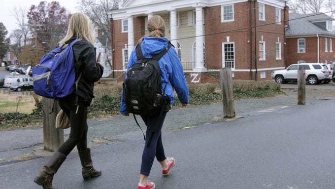 Students walk past the Phi Kappa Psi fraternity house on the University of Virginia campus on Dec. 6, 2014, in Charlottesville, Va.