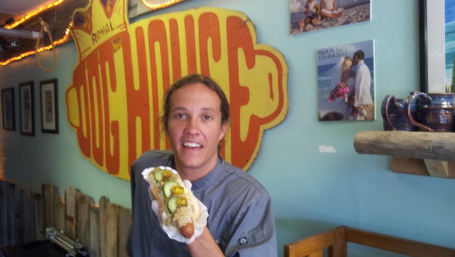 Nathan Holler chows down at his Pensacola Beach hot dog shop, the Dog House Deli.