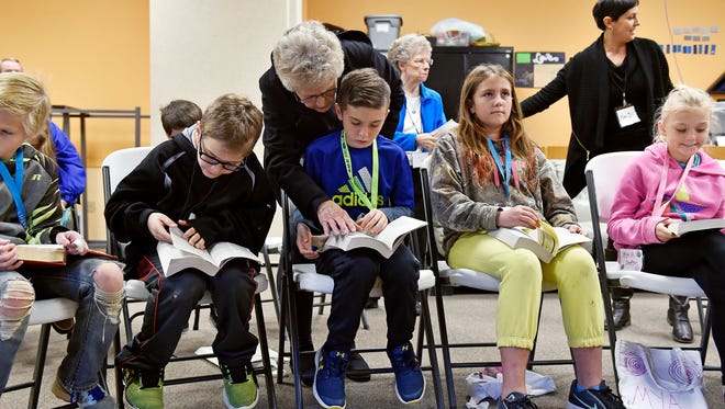 Volunteer Carol Corwell, back, helps Hunter Naugle, 10, find a verse in his Bible during released time Nov. 9, at Valley View Alliance Church in Hellam, Pa.