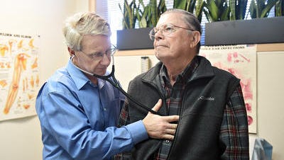 Dr. Cory Carroll listens to 85-year-old patient Stephen Hyatt's heart on Feb. 5. Carroll has transitioned his practice into the direct primary care model, which bypasses insurance companies. Patients pay a monthly fee for treatment.