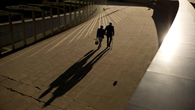 FILE - In this Thursday, Sept. 27, 2018 file photo, an elderly couple walks past the Berlaymont building, the European Commission headquarters, in Brussels. Research released on Sunday, July 14, 2019 suggests that a healthy lifestyle can cut the risk of developing Alzheimer's even if you've inherited genes that raise your risk for the mind-destroying disease. (AP Photo/Francisco Seco, File)