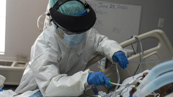 A member of the medical staff wearing full PPE bru