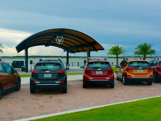 row of multi colored chevy bolts parked outside the bandshell