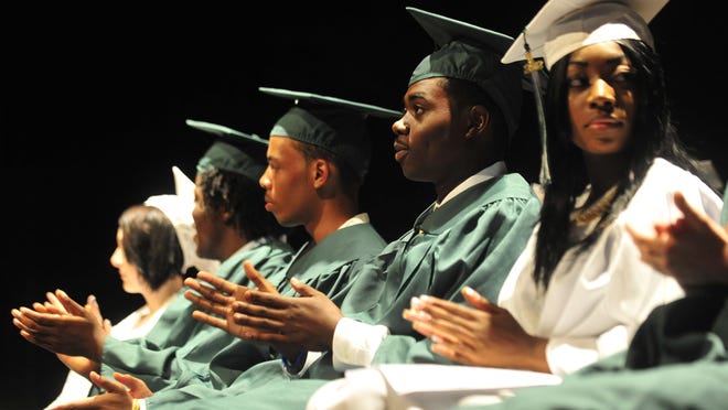 File - Graduates clap after a speech during Classic City High School commencement exercises in May 2012.