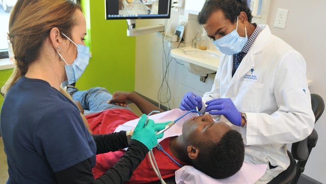 Dr. Sadesh Kumar, DMD, works on a patient at Wickham Dental Care in Melbourne.