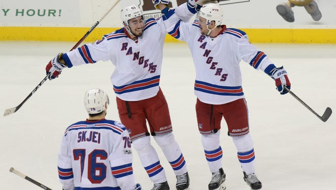 New York Rangers' Adam Clendening, right, celebrates his goal with Mika Zibanejad as Brady Skjei (76) looks on during the third period of an NHL hockey game against the New Jersey Devils, Saturday, Feb. 25, 2017, in Newark, N.J. (AP Photo/Bill Kostroun)