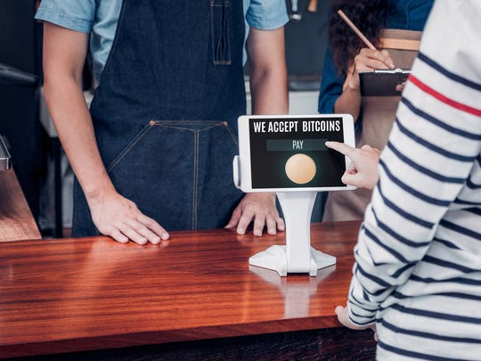 A point-of-sale device that reads, "We accept bitcoins."