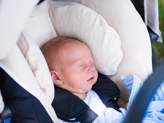 Newborn baby boy sleeping in car seat