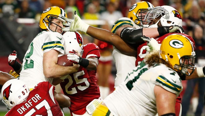 A host of Cardinals sack Green Bay Packers quarterback Aaron Rodgers during Arizona’s 38-8 victory on Dec. 27, 2015, in Glendale.