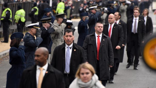 Secret Service agents walk the parade route as...