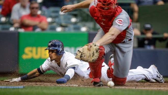 Orlando Arcia slides across home plate with the go-ahead run for the Brewers in the sixth inning against the Reds on Thursday at Miller Park. Arcia scored all the way from first base on Brett Phillips' two-out double.