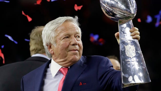 New England Patriots owner Robert Kraft hoists the Vince Lombardi Trophy after Super Bowl 51.