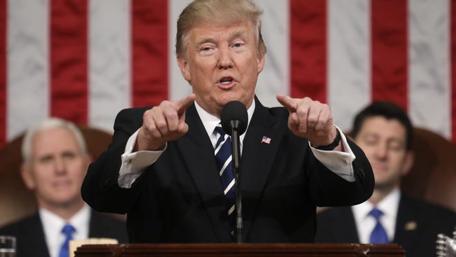 President Donald Trump addresses a joint session of Congress on Capitol Hill in Washington on Tuesday as Vice President Mike Pence and House Speaker Paul Ryan of Wis., listen.